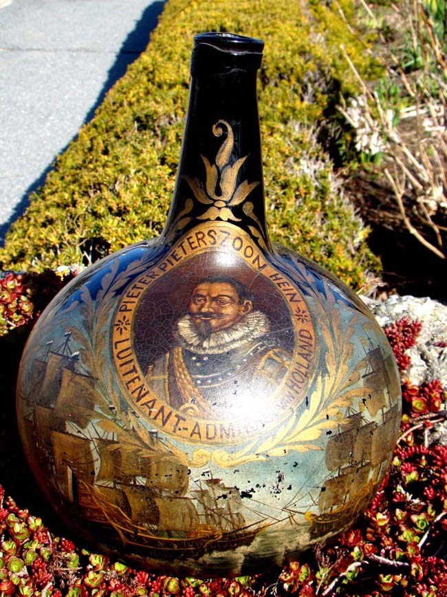 A rare early 18th century Dutch painted blown glass wine bottle with portrait of Lt. Admiral Pieter Pieterszoon Hein (1577-1629), Admiral of the Dutch fleet.
